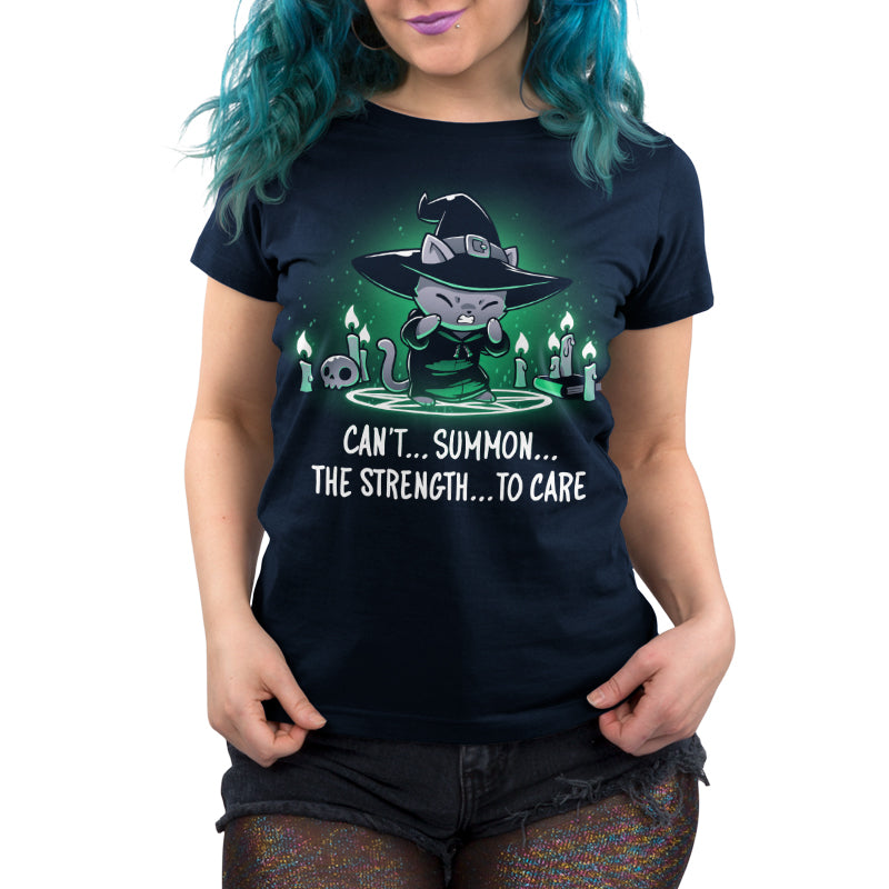 Women's Premium T-shirt_TeeTurtle Can't Summon The Strength To Care Navy Blue t-shirt featuring a grey cat in a black witch's hat and black robe struggling to cast a spell. It's standing in a summoning circle with candles, a scull, and a book around it. It is surrounded by a green glow. Text underneath it says "Can't... summon... the strength... to care"