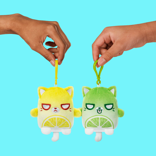 A pair of magnetic hands holding two Plushiverse Sourpuss Plushmates Besties keychains by TeeTurtle.