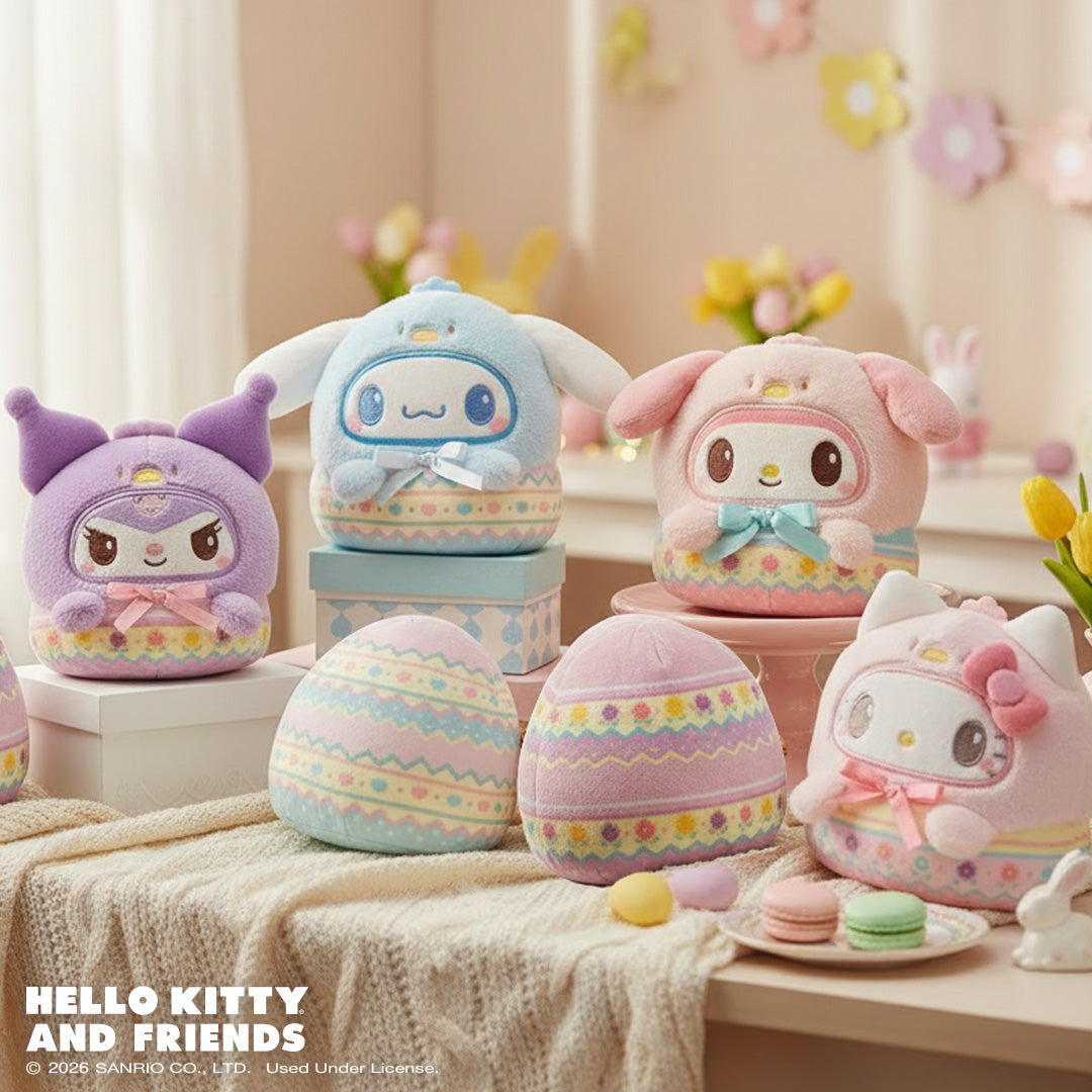 Easter Egg Kuromi 4" Reversible Plushie, Easter Egg Cinnamoroll 4" Reversible Plushie, Easter Egg My Melody 4" Reversible Plushie, and Easter Egg Hello Kitty 4" Reversible Plushie sitting on a table surrounded by Easter elements, such as eggs, a bunny carving, flowers, and macaroon, with more spring flowers in the background