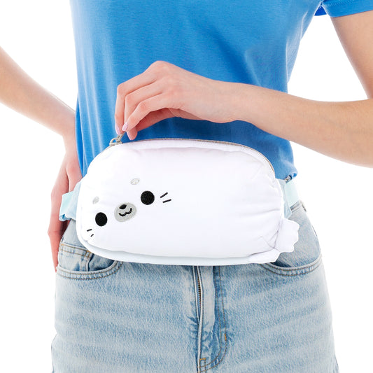A person wearing jeans holds a TeeTurtle Plushiverse Keep it Seal Plushie Fanny Pack around their waist.