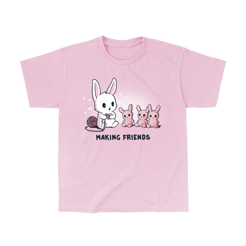 Classic Cotton T-shirt_Teeturtle Making Friends light Pink t-shirt Featuring a white-furred bunny knitting bunny friends out of yarn.