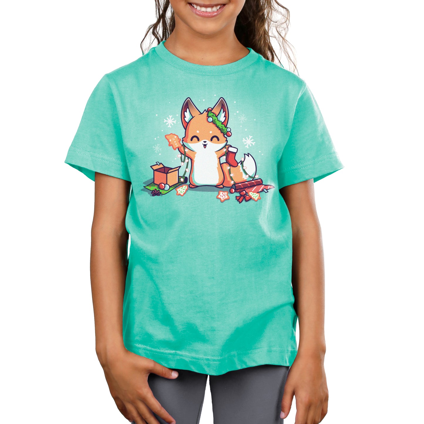 A girl enjoying comfort in her green "It's That Time of Year" t-shirt by TeeTurtle with a fox on it while engaging in holiday activities.