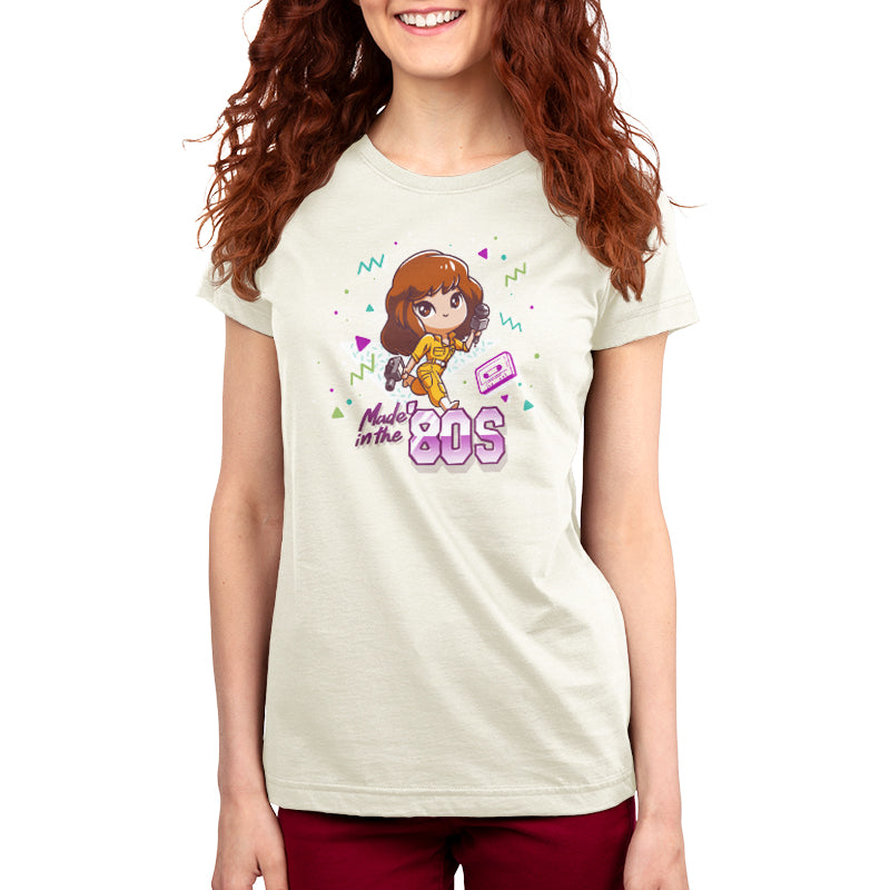 Premium Cotton T-shirt_TeeTurtle natural heather Made in the 80s apparel featuring April O'Neil from Teenage Mutant Ninja Turtles holding a camcorder and microphone with 90's elements in the background, such as a cassette tape, and the caption, "Made in the 80s".
