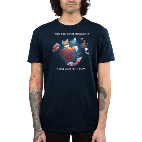 Premium Cotton T-shirt_TeeTurtle navy blue Anti-Gravity Enthusiast apparel featuring a fox wearing glasses reading a book with floating in mid-air with its living room furniture, such as a chair, rug, and lamp, with the caption, “I’m Reading About Anti-Gravity, I Just Can’t Put It Down“.
