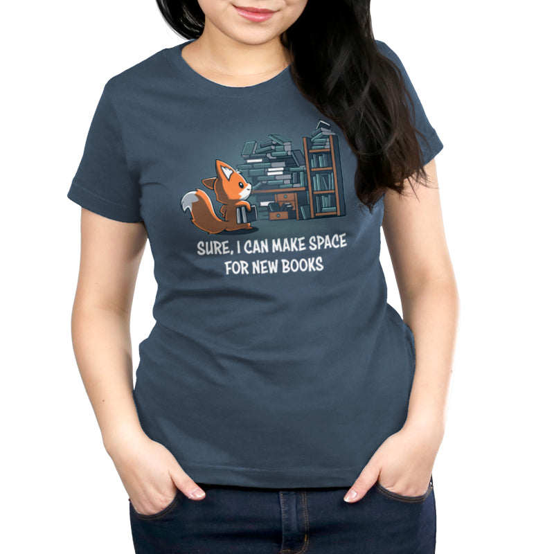 A woman wearing a dark blue unisex tee with a cartoon fox and books, featuring the text "sure, i can make space for new Never-Ending Bookshelf by monsterdigital.