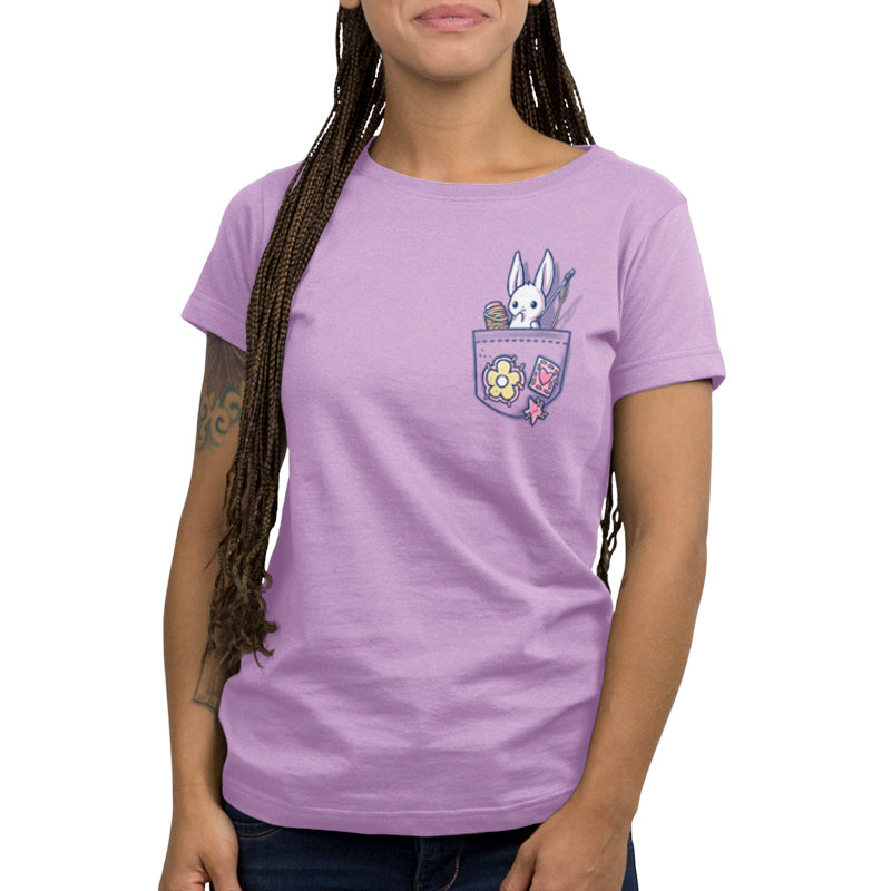 A woman wearing a lavender t-shirt with a Crafty Bunny in Your Pocket from TeeTurtle, showcasing her craft project.
