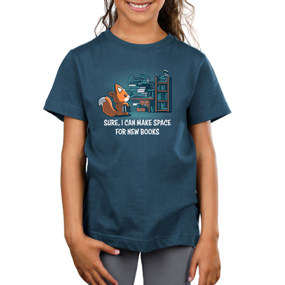 A young girl wearing a dark blue unisex tee with a cartoon fox and a quote about making space for new Never-Ending Bookshelf books printed on the front by monsterdigital.