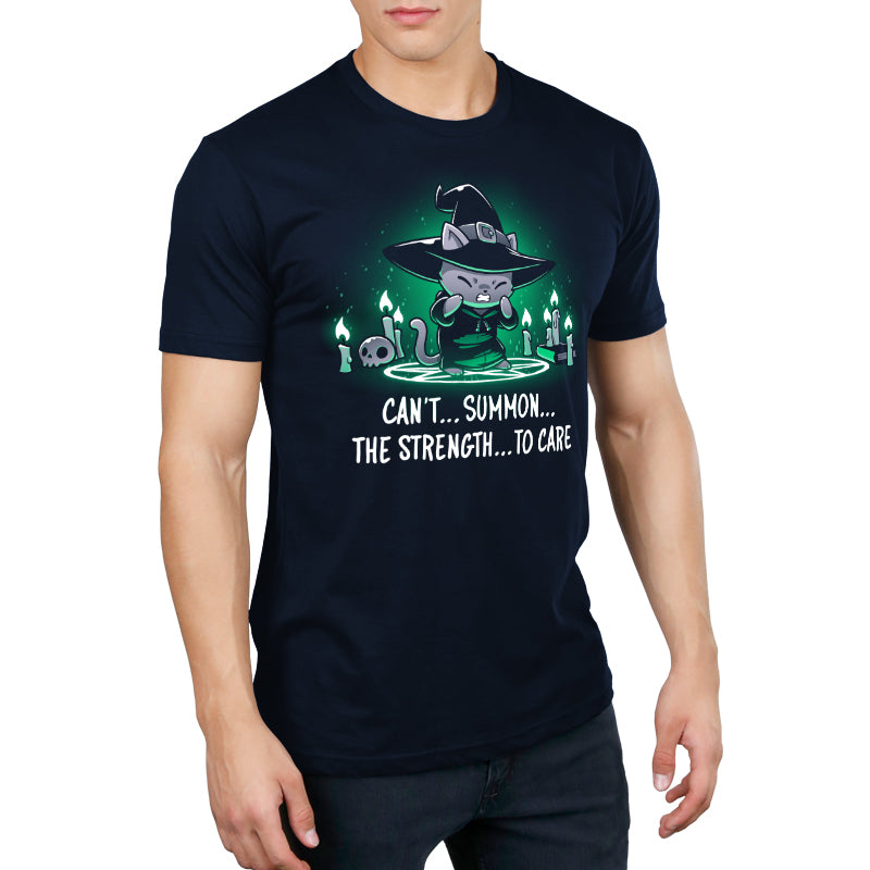 Premium Cotton T-shirt_TeeTurtle Can't Summon The Strength To Care Navy Blue t-shirt featuring a grey cat in a black witch's hat and black robe struggling to cast a spell. It's standing in a summoning circle with candles, a scull, and a book around it. It is surrounded by a green glow. Text underneath it says "Can't... summon... the strength... to care"