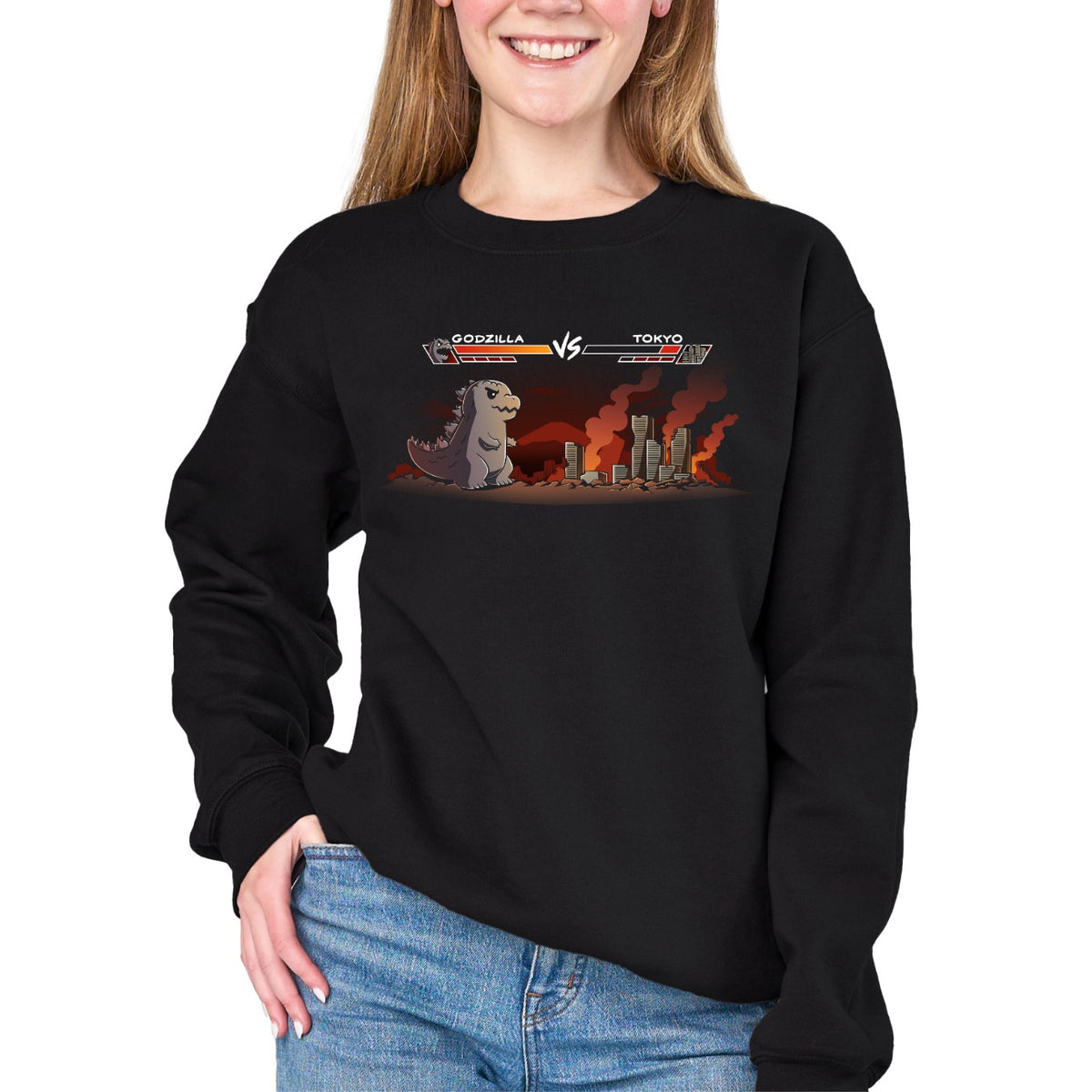 Crew Neck Sweatshirt_TeeTurtle black Godzilla Fight Screen Crew Neck Sweatshirt featuring Godzilla facing a burning Tokyo skyline in a retro fighting game scene with health bars labeled "Godzilla" and "Tokyo."