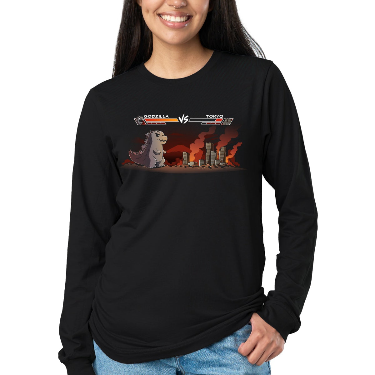 Long Sleeve T-shirt_TeeTurtle black Godzilla Fight Screen Long Sleeve T-shirt featuring Godzilla facing a burning Tokyo skyline in a retro fighting game scene with health bars labeled "Godzilla" and "Tokyo."