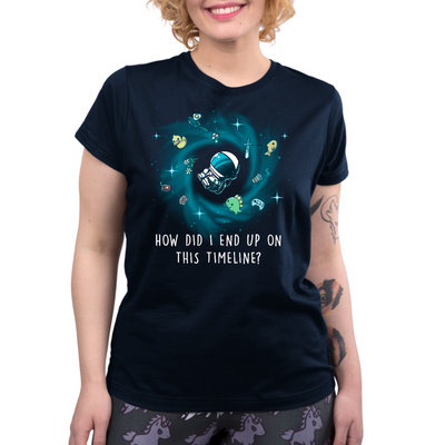 Premium Cotton T-shirt_TeeTurtle navy How Did I End Up On This Timeline Premium Cotton T-shirt featuring an astronaut floating in the middle of a black hole surrounded by random objects like a sword, frying pan, rubber duck, and game controller. Below the illustration the text rreads "How Did I End Up On This Timeline?"