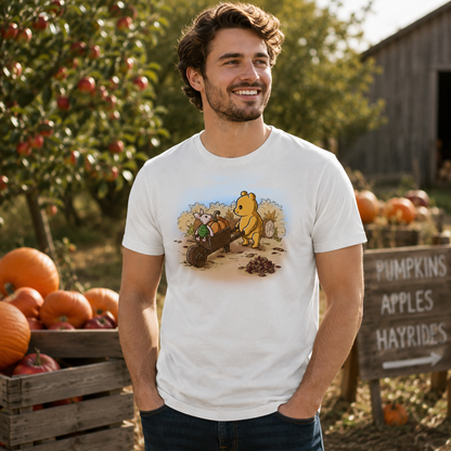 Premium Cotton T-shirt_TeeTurtle white A Perfect Autumn Day Premium Cotton T-shirt featuring a bear pulling a wagon filled with pumpkins while a little mouse rides along, surrounded by autumn bushes, fallen leaves, and tree stumps on a crisp fall day.