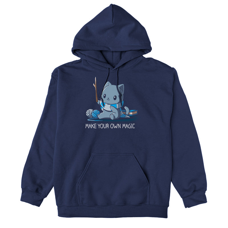 Pullover Hoodie_Teeturtle Make Your Own Magic Navy Blue Featuring a gray cat sitting in front of a book next to yarn with a wand-like stick and a crafted scarf with the text 'Make Your Own Magic' below.