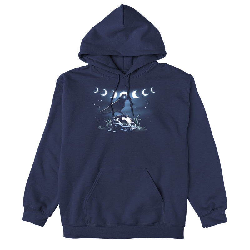 Pullover Hoodie_TeeTurtle Mystical Crow navy blue design featuring a crow with glowing eyes standing on an animal skull in a grassy area under a night sky.