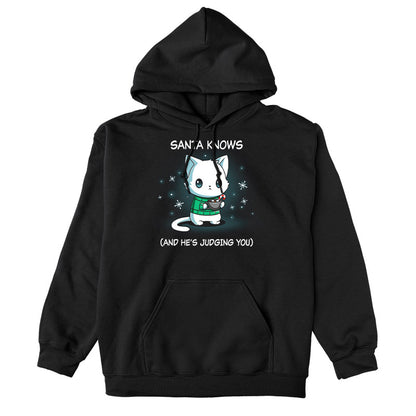 Pullover Hoodie_TeeTurtle black Santa Knows apparel featuring a cat with a deadpan expression holding mug with hot chocolate, marshmallows, and a candy cane surrounded by snowflakes, with the caption, “Santa Knows (And He’s Judging You)“.