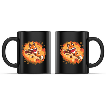 Ceramic Mug_TeeTurtle Autumn Fox black mug featuring a smiling fox wearing a cozy scarf while relaxing in a pile of colorful autumn leaves with leaves gently falling all around.