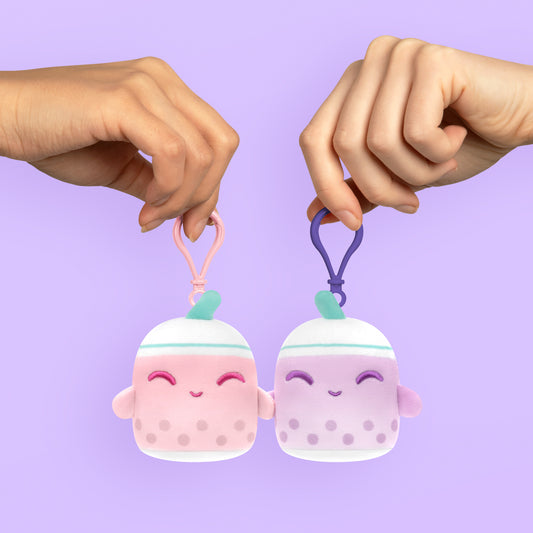 A pair of hands holding a pair of adorable pink and white TeeTurtle Plushiverse Boba Buddies Plushmates Besties mugs, perfect for Valentine's Day.
