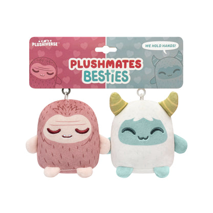 Two Plushiverse Yeti & Bigfoot plush toys labeled "TeeTurtle Plushmates Besties" with one resembling a pink monster and the other a blue creature, both with smiling faces, connected by magnetic hands.