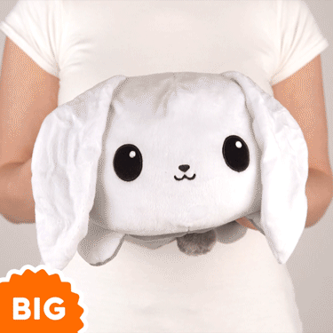 A woman is holding a TeeTurtle Big Reversible Bunny Plushie (White + Gray).