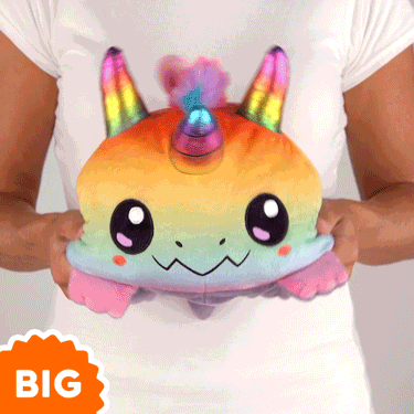 A woman is holding a TeeTurtle Big Reversible Dragon & Dragoncorn Plushie from TeeTurtle.