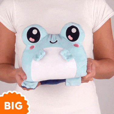 A woman is holding a TeeTurtle Big Reversible Frog Plushie.