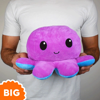 A man is holding a TeeTurtle Big Reversible Octopus Plushie (Purple + Blue) by TeeTurtle.