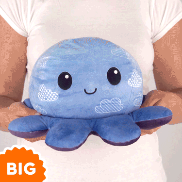 A woman is holding a TeeTurtle Big Reversible Octopus Plushie (Cloud Sky + Starry Sky).