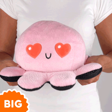 A woman is holding a TeeTurtle Big Reversible Octopus Plushie (Pink Sparkle + Black Sparkle).