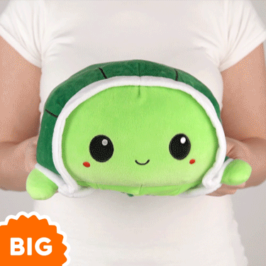 A woman is holding a TeeTurtle Big Reversible Turtle plushie (Green).