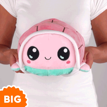 A woman is holding a TeeTurtle Big Reversible Turtle Plushie (Aqua + Pink).