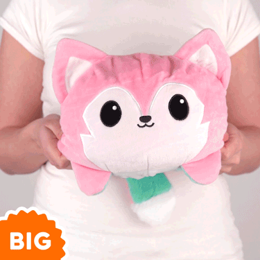 A woman is holding a TeeTurtle Big Reversible Wolf Plushie (Pink + Aqua).