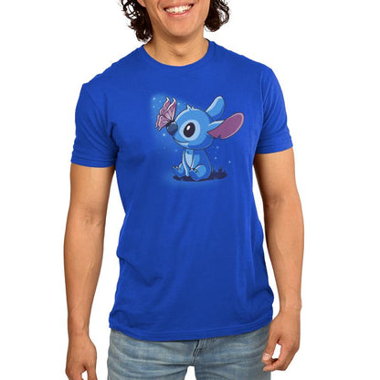 A young man wearing an officially licensed Disney blue t-shirt with an image of Butterfly Kisses (Stitch).