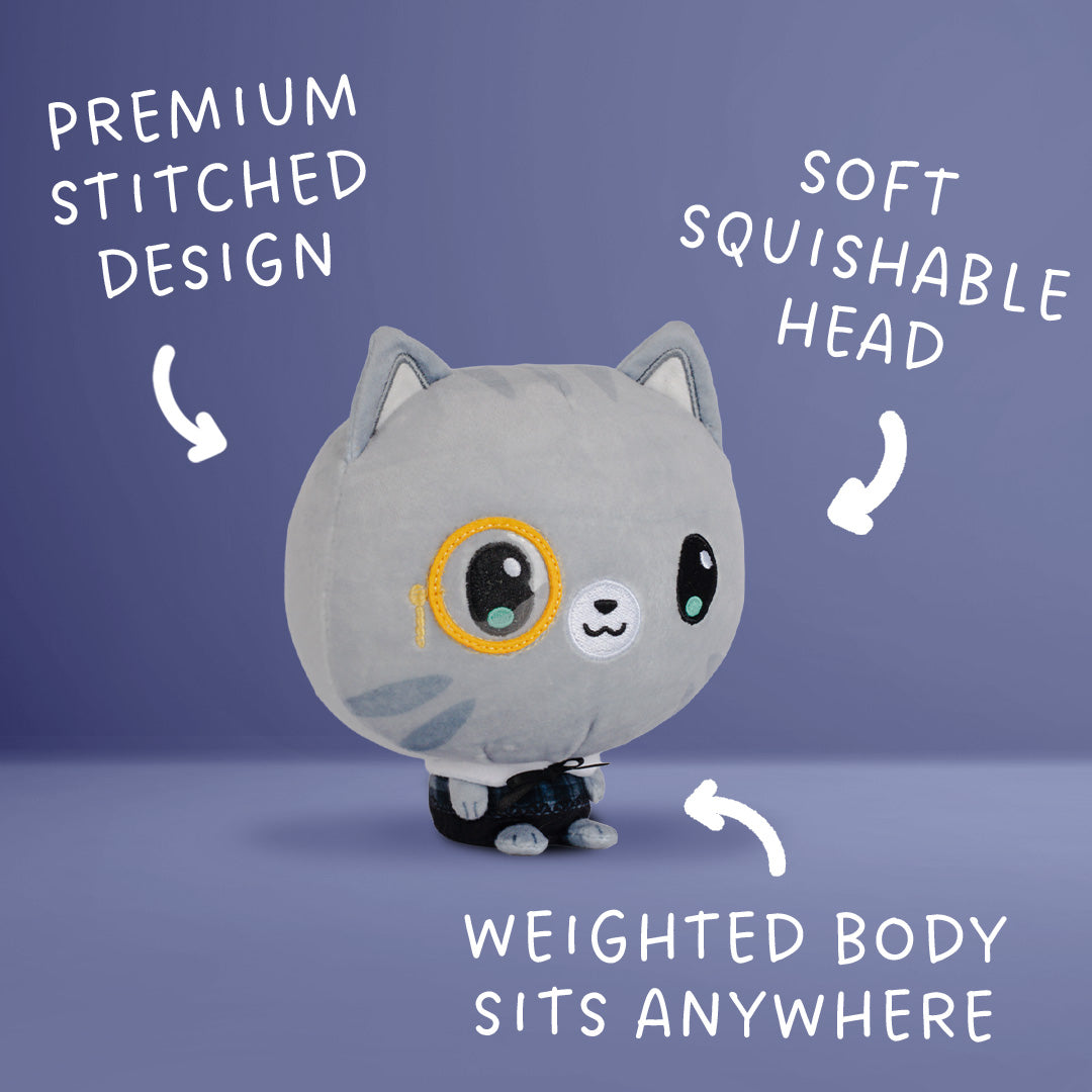 A gray plush cat toy with a round body, oversized stitched face, and small black-and-white feet, shown on a blue-purple background with white text callouts reading 'PREMIUM STITCHED DESIGN,' 'SOFT SQUISHABLE HEAD,' and 'WEIGHTED BODY SITS ANYWHERE.'.