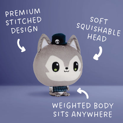 A plush toy character with a gray and wolf, large black eyes, a small black hat with a skull, and a plaid outfit, shown on a blue gradient background with white text callouts describing features.