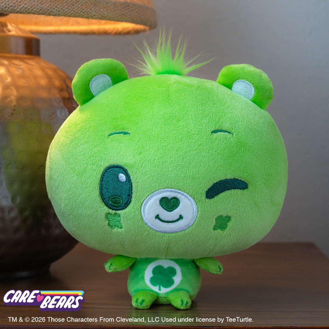 Good Luck Bear Care Bears Cloudhead sitting on a wooden desk next to a lamp. 