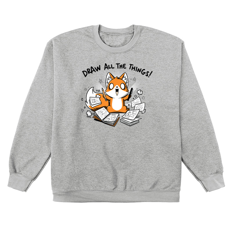 Crew Neck Sweatshirt_A cartoon fox enthusiastically holding drawing tools, surrounded by sketchbooks with various drawings. Text above reads "Draw All The Things!" This monsterdigital original Draw all the Things! is crafted from super soft ringspun cotton for ultimate comfort.