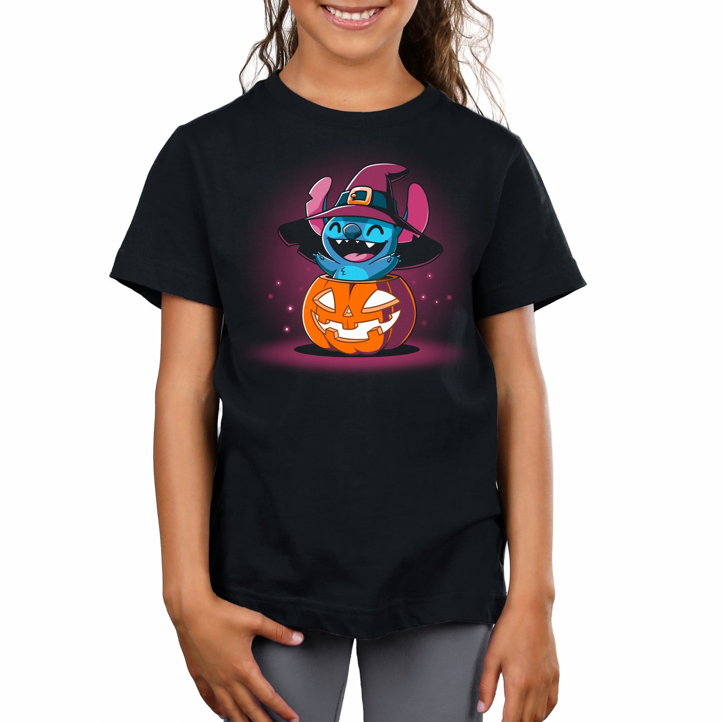 A girl wearing a Disney T-shirt with a Pumpkin Stitch cartoon witch.
