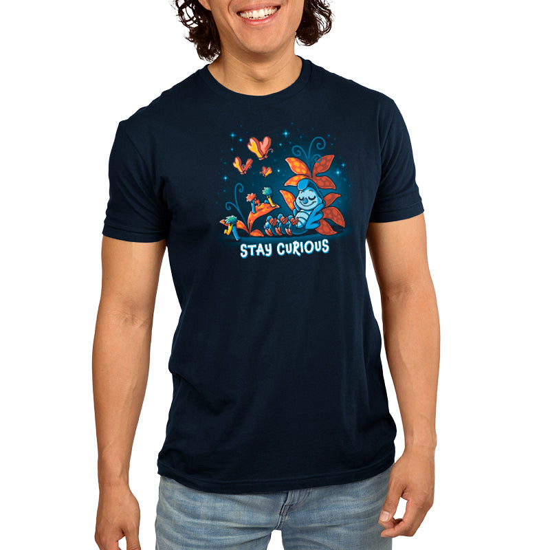 A man is wearing an officially licensed Disney t-shirt that says Stay Curious.