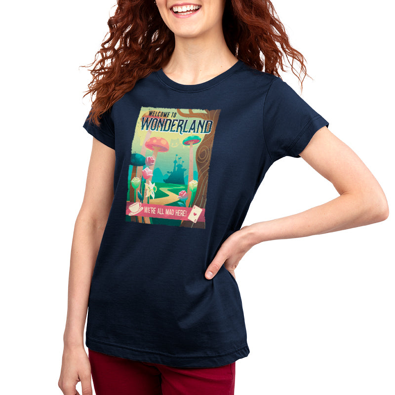 A woman wearing a Disney t-shirt with a picture of Wonderland Travel Poster in a park.