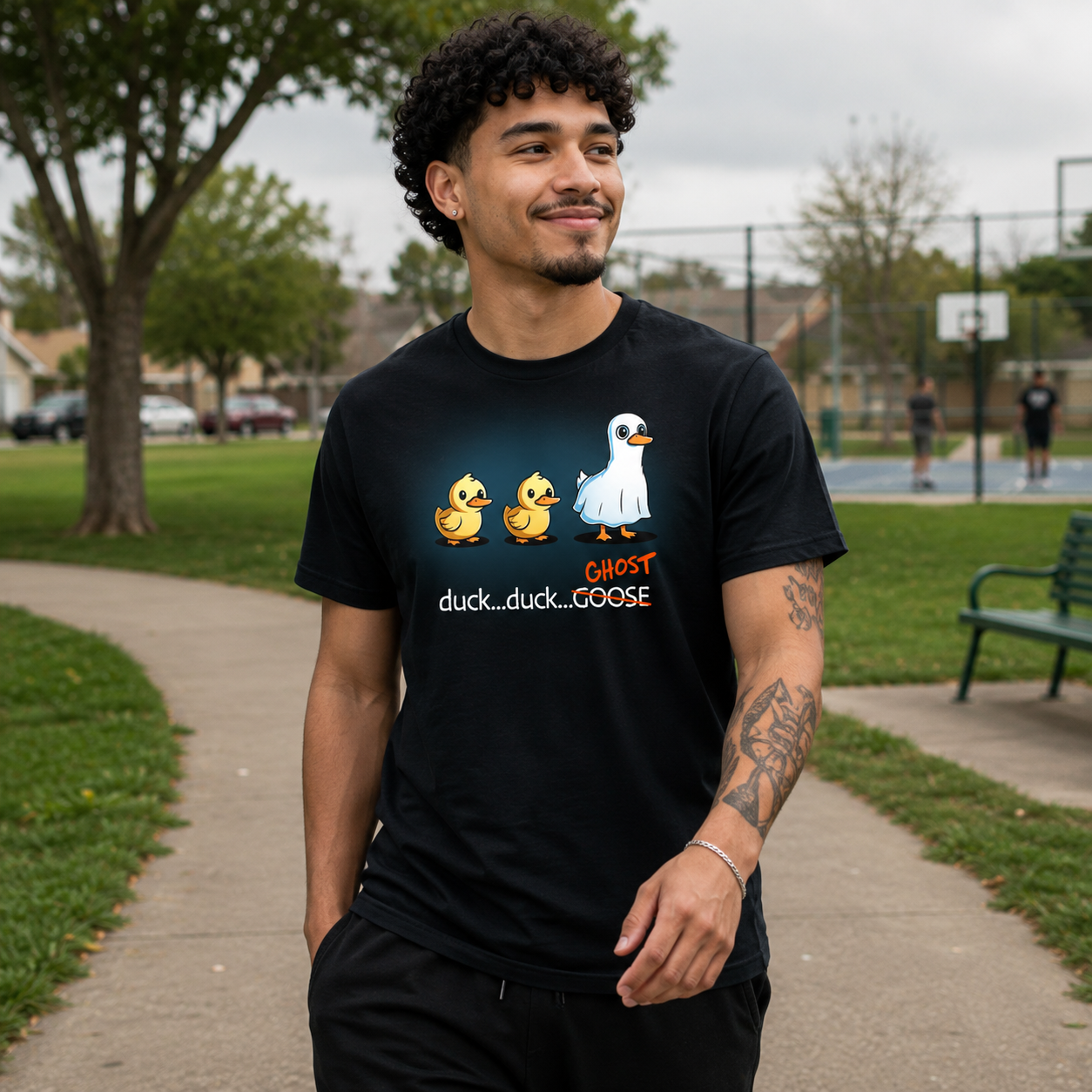 Premium Cotton T-shirt_TeeTurtle black Duck...Duck...Ghost Premium Cotton T-shirt featuring two normal ducks followed by a third duck dressed as a ghost in a white sheet, creating a playful twist on the classic "Duck, Duck, Goose" game.