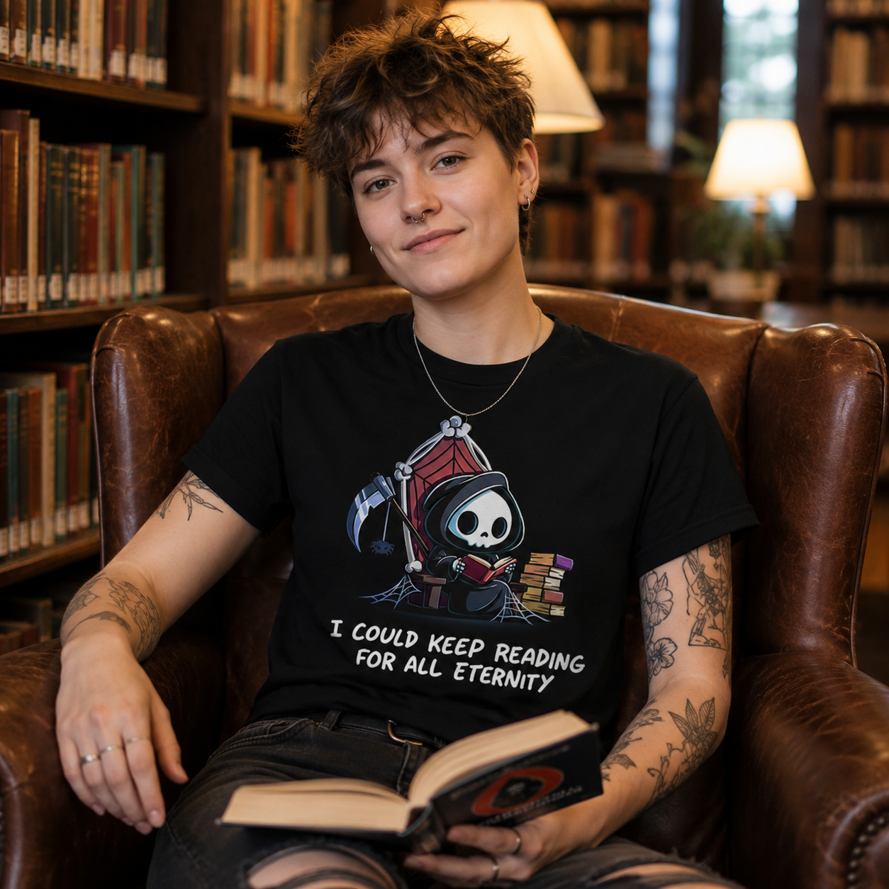 Premium Cotton T-shirt_TeeTurtle black Eternal Reader featuring the Grim Reaper on a cobwebbed throne reading a book with text, “I could keep reading for all eternity“.