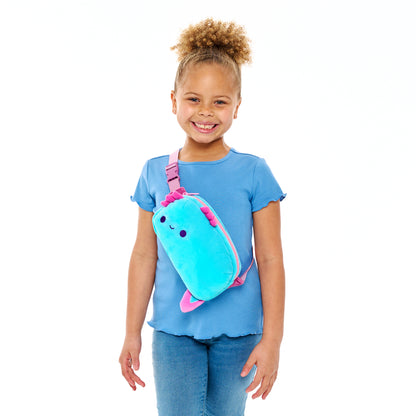 A smiling young girl with a ponytail, wearing a blue shirt and jeans, holding a Plushiverse Alotl Fun Plushie Fanny Pack from TeeTurtle.