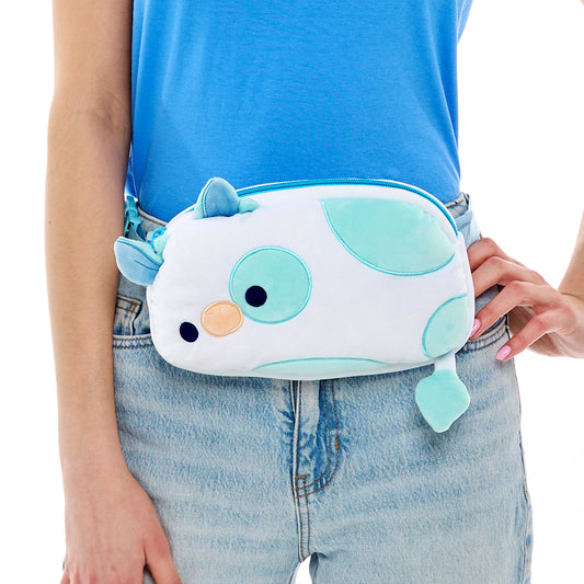Person wearing a blue t-shirt and denim jeans holding a TeeTurtle Plushiverse Udderly Adorable Plushie Fanny Pack with an adjustable belt.