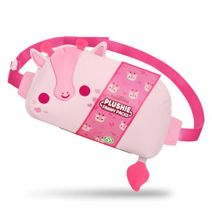 Pink plush fanny pack in the shape of an animal with ears and a tail, featuring a buckled pink strap. The tag reads "Plushiverse Blushing Giraffe Plushie Fanny Pack" by TeeTurtle. The adjustable belt ensures hands-free functionality for all your adventures.