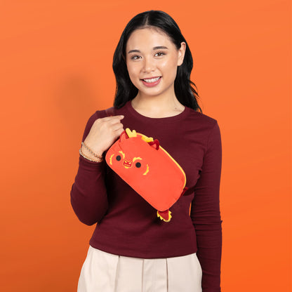 A woman sporting a TeeTurtle Plushiverse Lunar New Year Dragon Plushie Fanny Pack, showcasing hands-free functionality with an adjustable belt, adorned with a cat design.