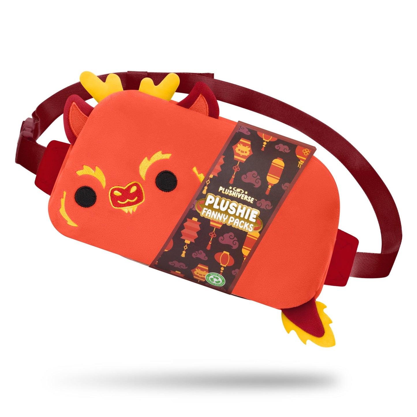 A red TeeTurtle Plushiverse Lunar New Year Dragon Plushie Fanny Pack with a cute dragon design and decorative label, perfect for the Lunar New Year collection. The background features lanterns and scroll patterns, enhancing its festive charm. The strap is attached and visible, offering hands-free functionality for your convenience.