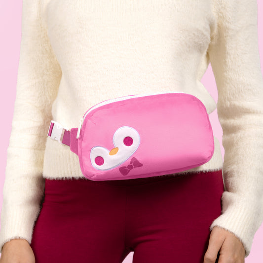 A woman wearing a Plushiverse Dapper Penguin Plushie Fanny Pack by TeeTurtle with an adjustable belt.