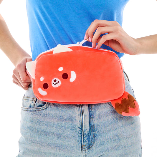 Person holding a Plushiverse Cheery Red Panda Plushie Fanny Pack designed by TeeTurtle, complete with an adjustable belt.