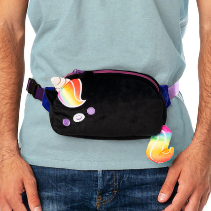 Person wearing a gray t-shirt and jeans with an adjustable belt black TeeTurtle Plushiverse Unicorn Pride Plushie Fanny Pack featuring a unicorn theme, complete with a rainbow-colored horn and tail for hands-free functionality.