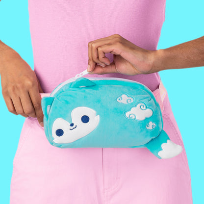 A woman is holding a TeeTurtle Plushiverse Fair Weather Wolf Plushie Fanny Pack with an adjustable belt.